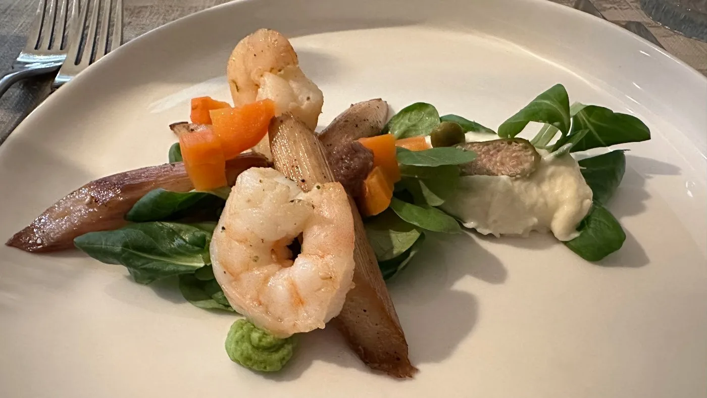 Foto van Asperges met quenelles van asperge, erwten- en uienmouses op een bed van veldsla, afgewerkt met enkele gamba's