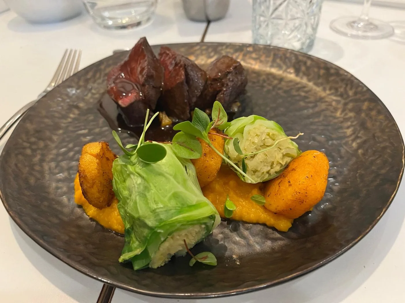 Voorbeeld van Hert met pompoen, perencompote, koolrolletie en jus van gebakken ui