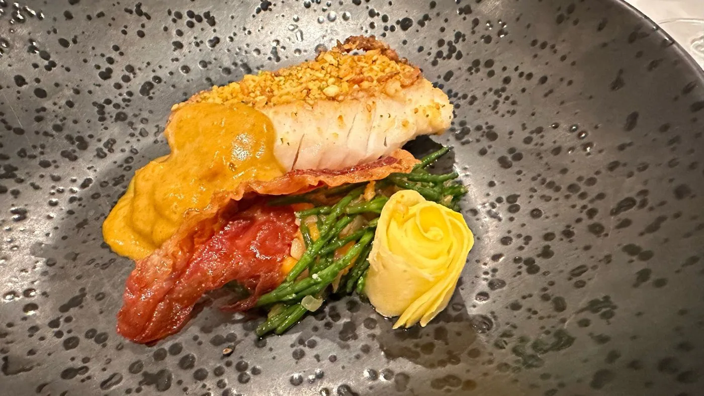 Voorbeeld van Op de huid gebakken vis met schubben van gele biet en wortel, romige pompoencrème, zeekraal of wier, afgewerkt met een krokantje van spek of ham, een verfijnde saffraansaus en cress