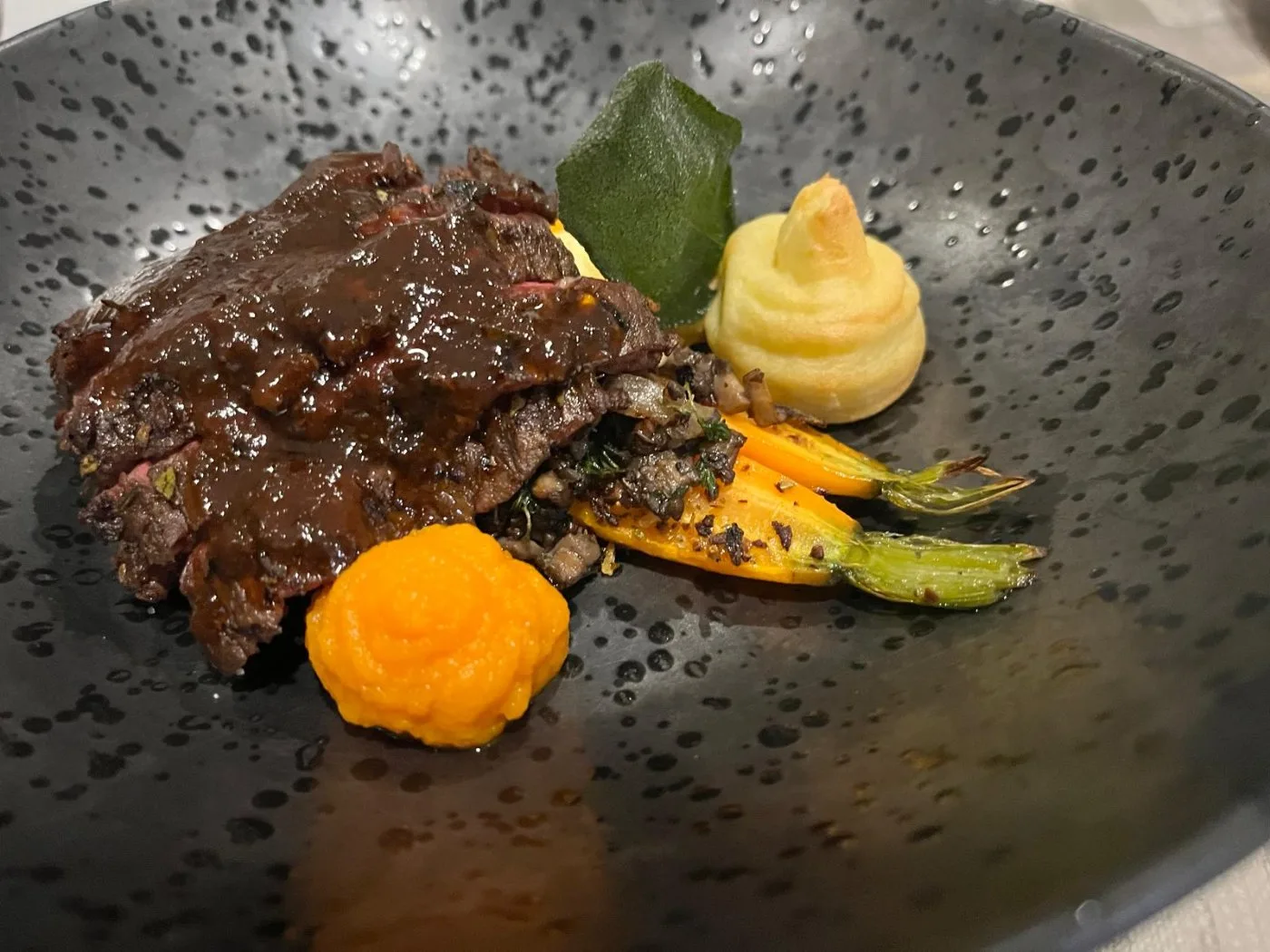 Voorbeeld van Bavette met wortel, pommes dauphine, paddestoel en rode wijn jus